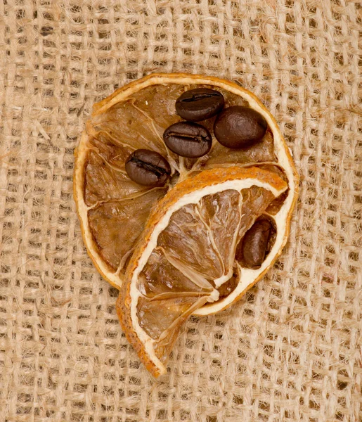 Limones y granos de café en arpillera —  Fotos de Stock