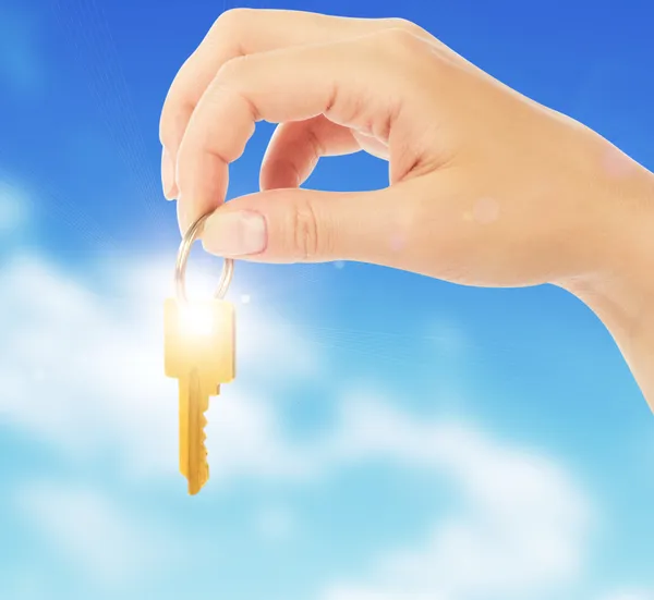 Hand holds a gold key — Stock Photo, Image