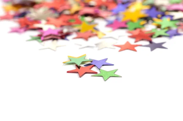 Decoração de Natal de estrelas de confete coloridas contra branco — Fotografia de Stock