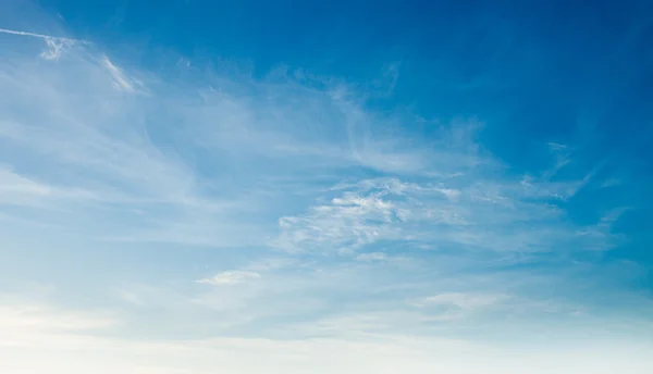 Blauwe lucht achtergrond met kleine wolken — Stockfoto
