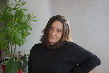 39 yaşında, gri saçlı bir kadının portresi.