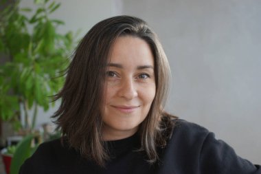 39 yaşında, gri saçlı bir kadının portresi.