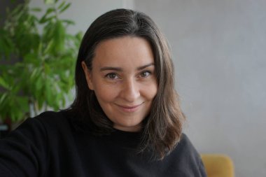 39 yaşında, gri saçlı bir kadının portresi.