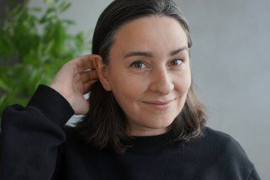 39 yaşında, gri saçlı bir kadının portresi.