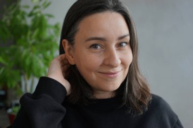 39 yaşında, gri saçlı bir kadının portresi.