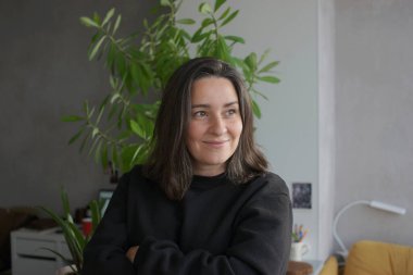 39 yaşında, gri saçlı bir kadının portresi.