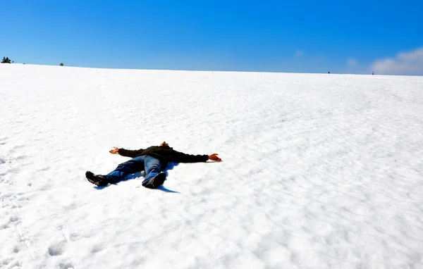 Muž leží na sněhu — Stock fotografie