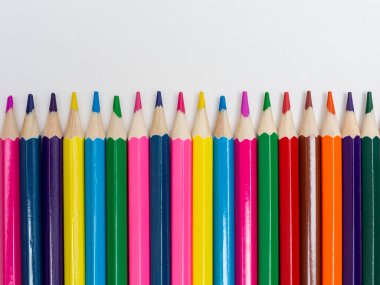 Beyaz arkaplanda bir sıra renkli kalem.