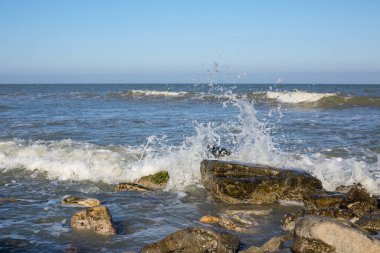 Deniz sörfü. Dalgalar kıyıdaki kayalara vuruyor..