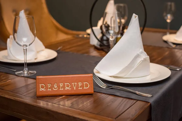 Reserved table in the restaurant. A sign with the inscription Reserved.