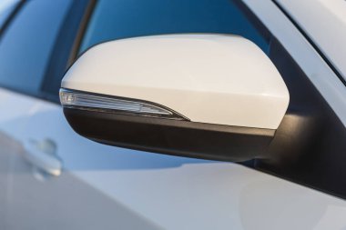 Modern bir arabanın yan aynası. Arabanın gövdesindeki elementler beyaz..