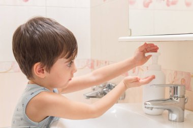 Çocuk ellerini el yıkama köpüğüyle sabunluyor. Temizlik ve hijyen..