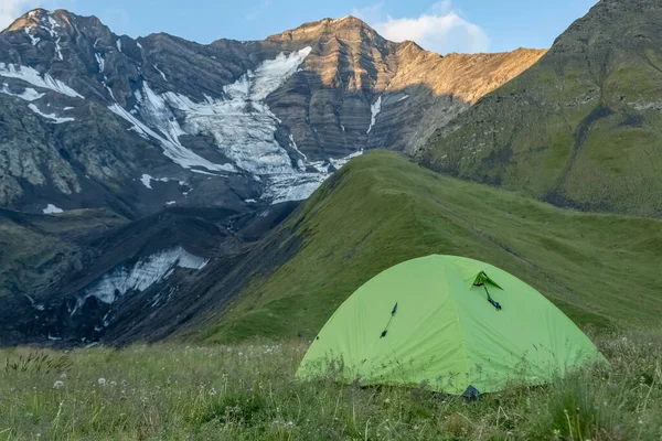 Dağların tepesinde yeşil bir çadır. Turizm ve seyahat.