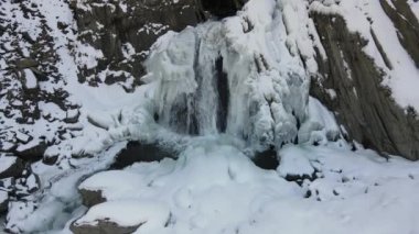 Dağlarda donmuş şelale. İnsansız hava aracı videosu. Chvakhilo Şelalesi, Charodinsky Bölgesi, Dağıstan, Rusya.