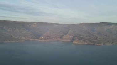 Dağlardaki bir gölün üzerinden İHA 'dan ateş etmek. Hava videosu. Cherkey rezervuarı, Dağıstan, Rusya.