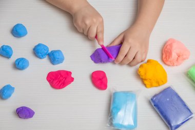 Bir çocuk çok renkli plastiklerle oynuyor. İyi motor becerilerin geliştirilmesi için çocuk oyunları.