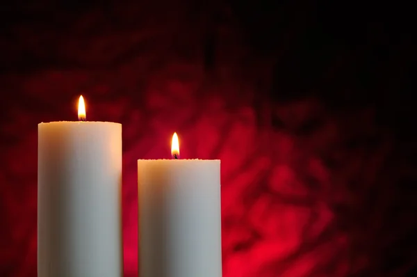 Two candles with red background — Stock Photo, Image