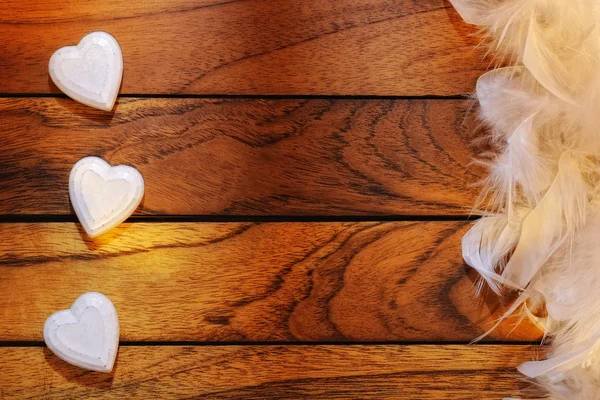 Three white hearts misaligned and feathers — Stock Photo, Image