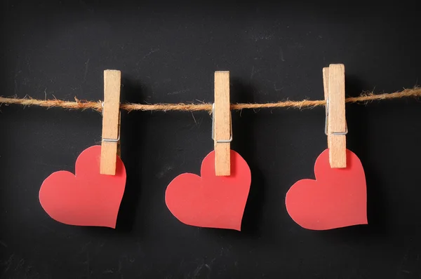 Three hearts hanging on blackboard — Stock Photo, Image