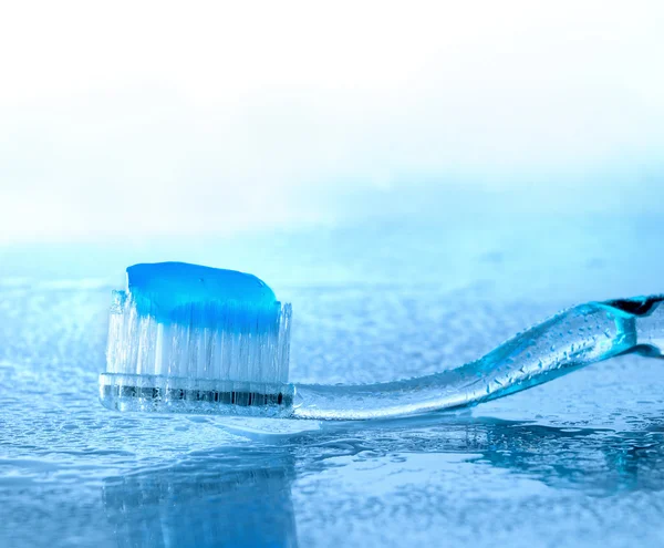 Tandenborstel met plakken op natte glas — Stockfoto