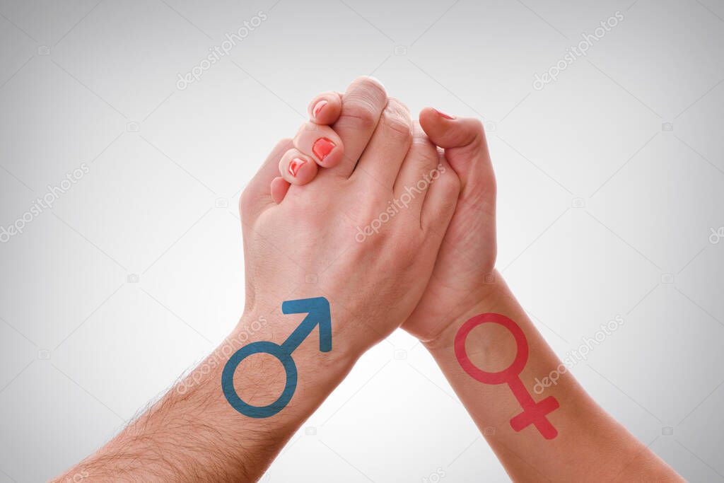 Competition between genders with two hands of both sexes throwing a pilso with a symbol drawn in the hands