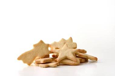 Beyaz masadaki izole edilmiş arka planda bulunan bir yığın Noel şekilli kurabiye. Ön manzara. Yatay bileşim.