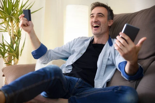 Boldog Ember Vásárol Online Egy Okos Telefon Feküdt Kanapén Otthon — Stock Fotó