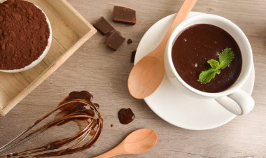 Mutfak masasında kremalı sıcak çikolata tarifi hazırlıyorum. Yüksek görünüm.