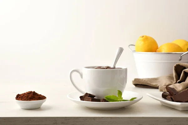 热巧克力在白色陶瓷杯 块和巧克力粉在碗上的木制桌子 白色孤立的背景 前面的景色1 横向构成 — 图库照片