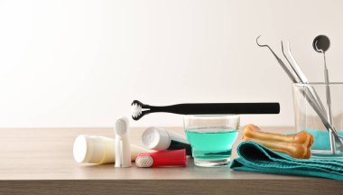 Profesyonel veteriner ürünleri ve köpek dişlerini ahşap masa ve izole bir arka planda temizlemek için aksesuarlar. Ön manzara. Yatay bileşim.