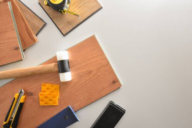 Arkaplan parke yükleyici malzeme ve araçlar beyaz masa üzerinde