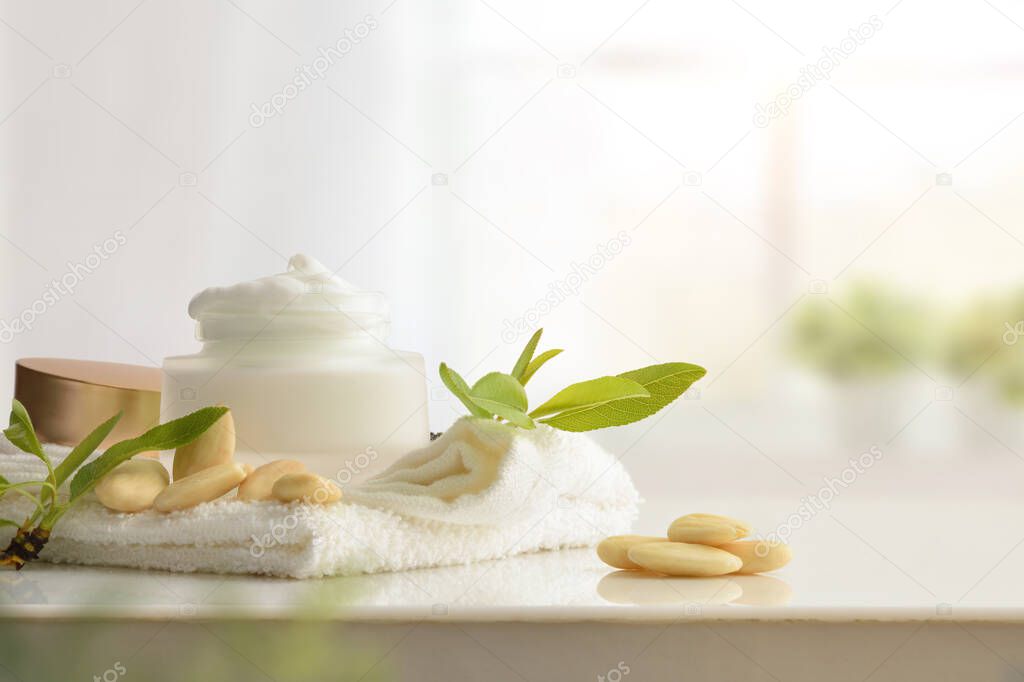 Moisturizing cream with almond extract on white table with fruits in thebathroom. Front view. Horizontal composition.
