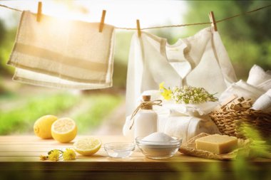 Ekolojik ve ev yapımı temizlik ürünleri ahşap masada asılı ve giysiler yeni yıkanmış. Ön manzara. Yatay bileşim.