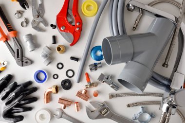 Su tesisatı malzemeleri ve beyaz tezgahtaki aletler. Üst Manzara. Yatay bileşim.