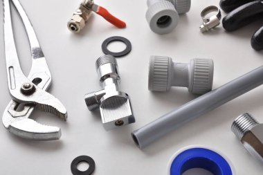 Detail of group of plumbing equipment on white workbench. Elevated view. Horizontal composition.
