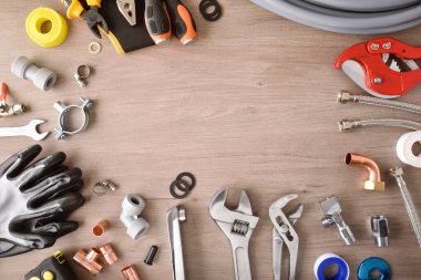 Plumbing materials and tools on wooden workbench top view frame background. Top view. Horizontal composition.