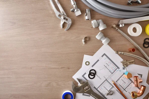 Planlar ve su tesisatı malzemesi ahşap masada. Üst Manzara. Yatay bileşim.