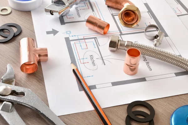 Planlar ve su tesisatı malzemesi ahşap masada. Manzara yükseldi. Yatay bileşim.