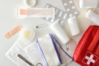 Beyaz masadaki acil ilk yardım çantasının çeşitleri. Yatay bileşim. Üst görünüm. 