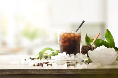 Arka planda, ahşap mutfak tezgahında buzlu kahve içeceği ve etrafında buz olan bir kase vardı. Ön manzara. Yatay bileşim.