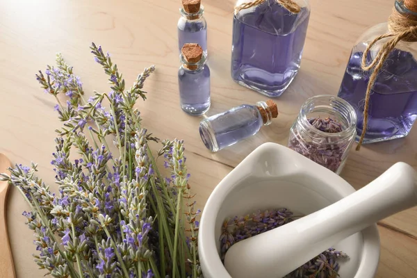 Homemade preparation of natural lavender essence with elements for the preparation and containers with lavender liquid close up. Elevated view. Horizontal composition.