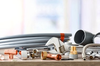 Tesisat malzemesi ahşap masa ve arka plandaki pencere üzerinde işe yarıyor. Ön manzara. Yatay bileşim.