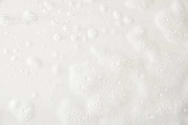 Foam texture on a white base with traces of soap and shower water detail. Top view. Horizontal composition.