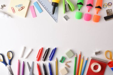 Assortment of colorful school supplies arranged on white table. Top view. Horizontal composition.