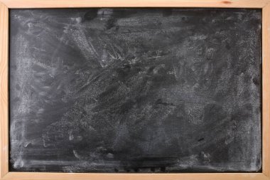 Detail of chalk stained black board with wooden frame. Horizontal composition.