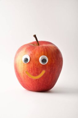 Healthy red apple with face on white isolated background. Fruits and vegetables child healthy eating concept