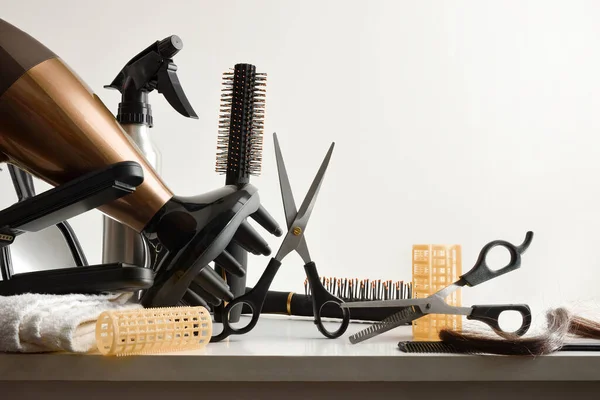 Hairdressing tools on white workbench with white isolated background. Front view. Horizontal composition.