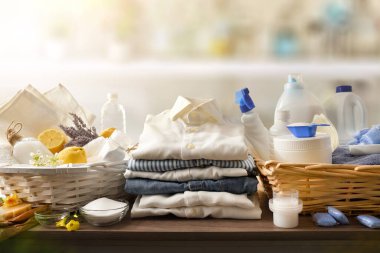 Detail comparison of ecological laundry cleaning products on wooden table and chemicals in domestic laundry. Front view. Horizontal composition.