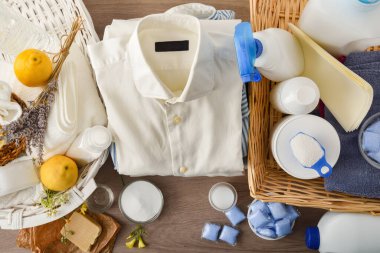 Detail comparison of ecological laundry cleaning products on wooden table and chemicals on white table. Top view. Horizontal composition.