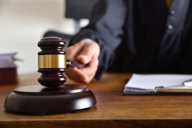 Tahta bir masada tokmakla vurarak hüküm veren bir yargıcın ayrıntıları. Ön görünüm